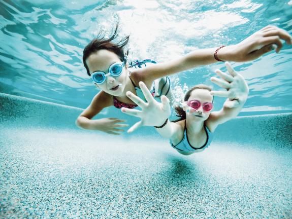 Der 1,5 stündige, kostenlose Eintritt ins Schwimmbad ist im Gästebeitrag enthalten Tauchende Kinder im Pool