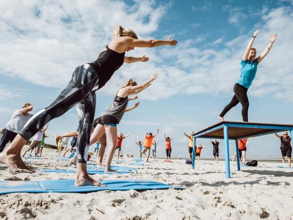 Der Sportstrand liegt direkt am Dünenübergang Hauptbad. Sommergäste beim Workout am Langeooger Sportstrand.