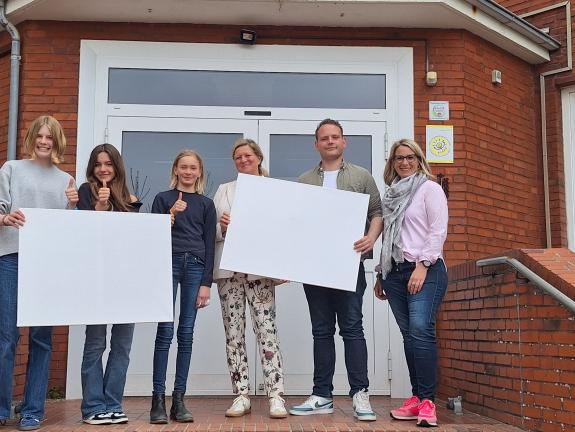 Auf dem beigefügtem Bild sind zusehen (von Rechts nach Links): Kerstin Hagenkötter (Mitarbeiterin WFV) Niklas Dillbohner (Standortleitung) Kirsten Rottmann (Kunstlehrerin) und Schülerinnen ihrer Klasse
