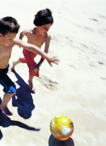 Kinder spielen am Strand